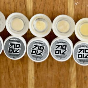 A lineup of cannabis concentrates from the 710 wax collection, featuring a variety of high-quality extracts like wax, live resin, and nug run, displayed in clear jars with vibrant colors